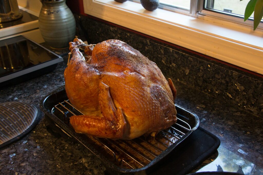 A turkey sitting on a rack in a kitchen