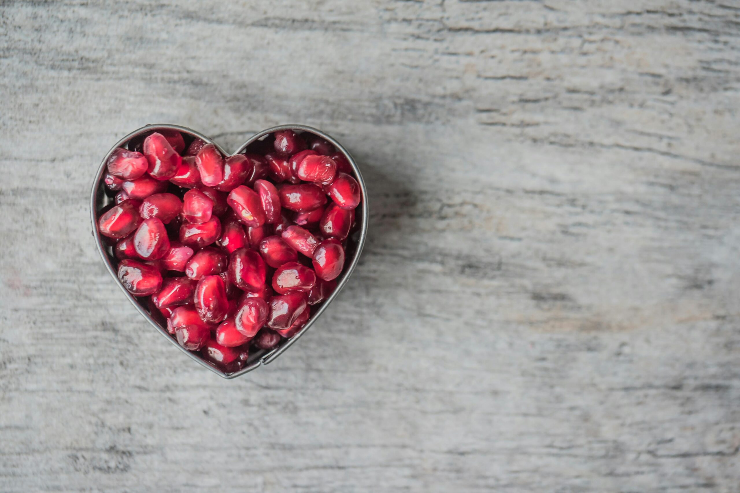 heart bowl filled with pomegranate seeds